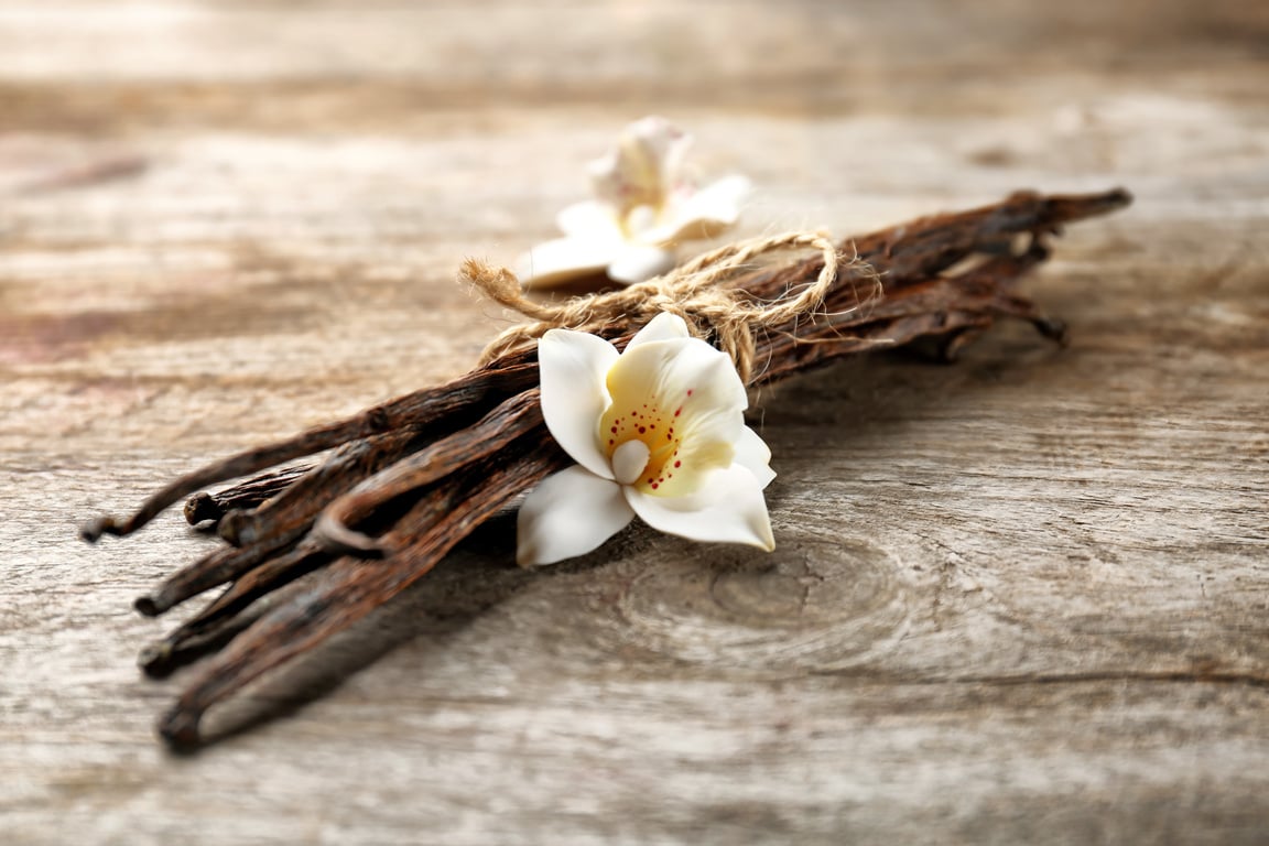 Dried Vanilla Pods and Flower on a Wooden Background